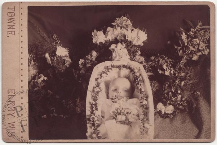 Baby in a coffin with flowers