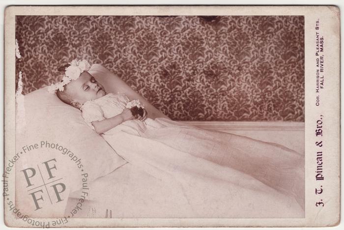 Infant with a wreath of white flowers