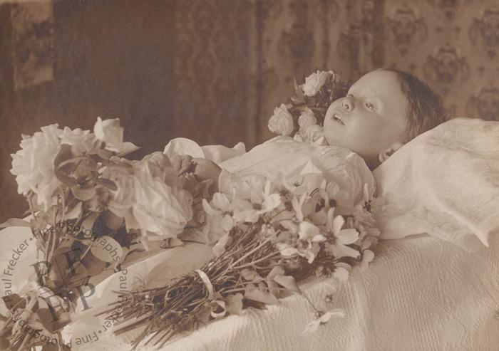 Waxen-faced child with flowers