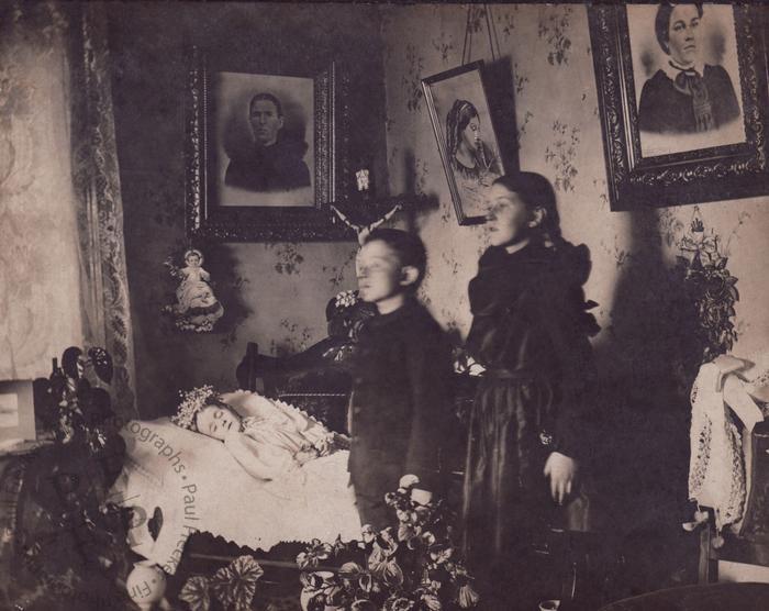 Brother and sister beside their dead sibling