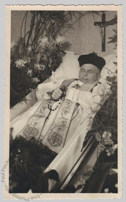 Priest in an open coffin