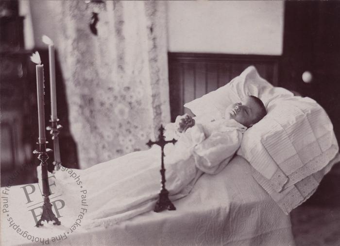 Child with a cross and candles