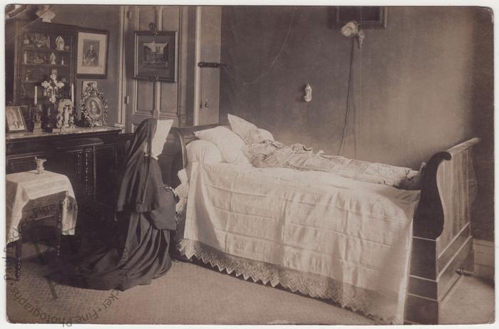 Nun praying beside a bishop's body
