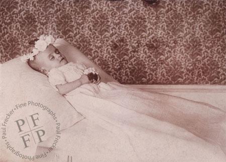 Infant with a wreath of white flowers