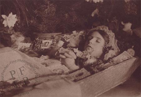 Woman in a coffin with prayer cards