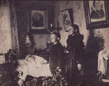 Brother and sister beside their dead sibling