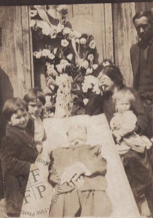 Weeping woman beside an open coffin